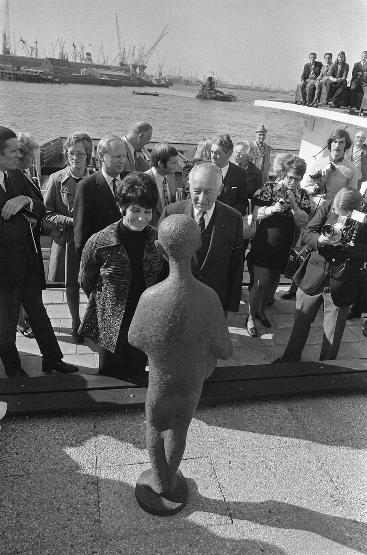 onthulling-1973 Zwart-witfoto uit 1973: Mies Bouwman bij het net onthulde beeld van Ketelbinkie, met havenkranen op de achtergrond